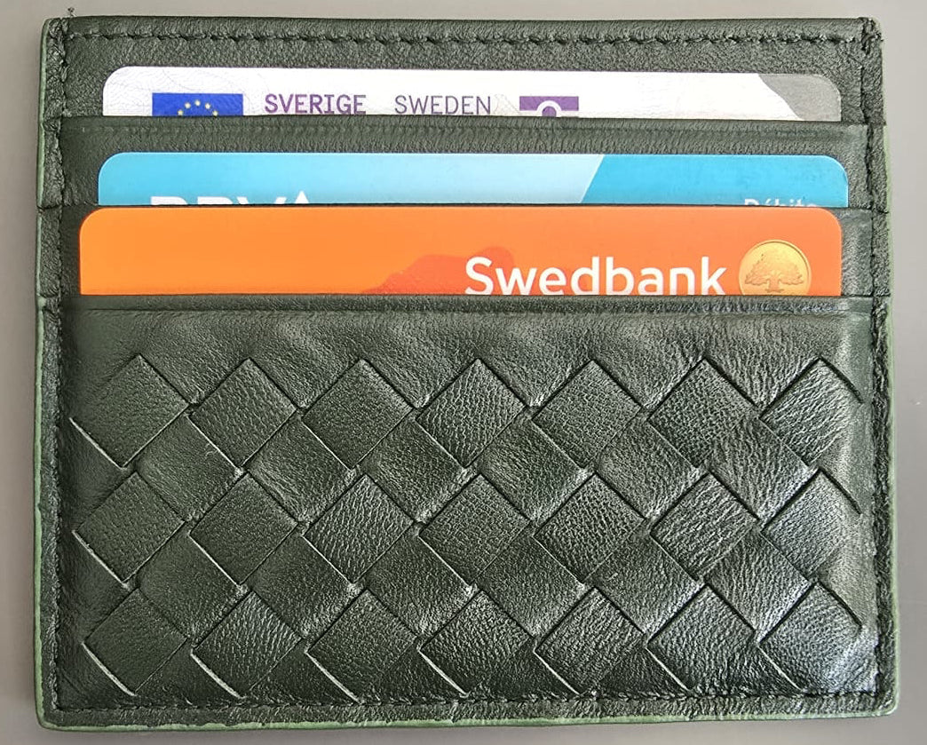 A dark green woven leather cardholder wallet with four card slots containing sample credit cards, shown on a neutral gray background.