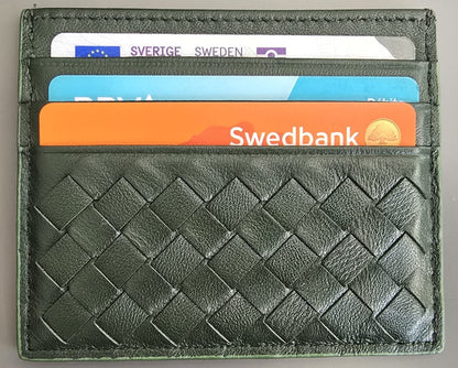 A dark green woven leather cardholder wallet with four card slots containing sample credit cards, shown on a neutral gray background.